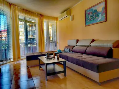 a living room with a couch and a table at Central Plaza Apartment in Sunny Beach