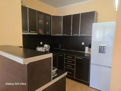 a kitchen with black cabinets and a white refrigerator at Central Plaza Apartment in Sunny Beach
