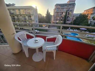 a balcony with a table and chairs and a pool at Central Plaza Apartment in Sunny Beach