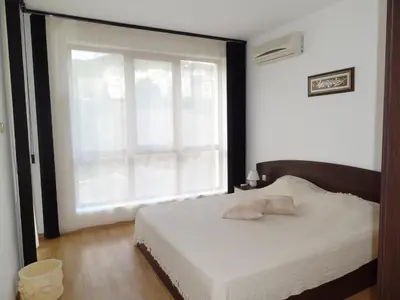 a bedroom with a bed and a large window at Triumph Holiday Village in Sveti Vlas