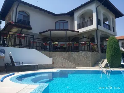 a house with a swimming pool in front of a house at Къща за гости Мускат 2 in Aheloy