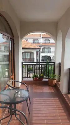 a balcony with a table and chairs and a building at Къща за гости Мускат 2 in Aheloy