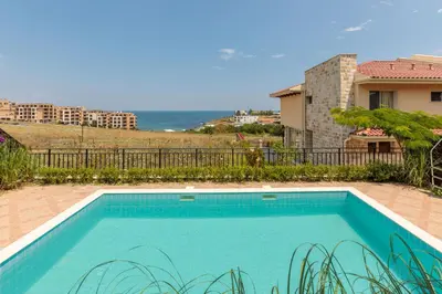 a swimming pool in front of a house at Coral Luxury Villas in Lozenets