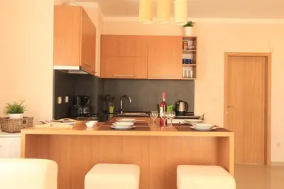 a kitchen with wooden cabinets and a counter top at Bay Apartments Sozopol in Sozopol