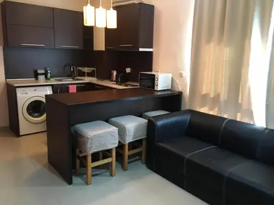 a living room with a couch and a kitchen at Bay Apartments Sozopol in Sozopol