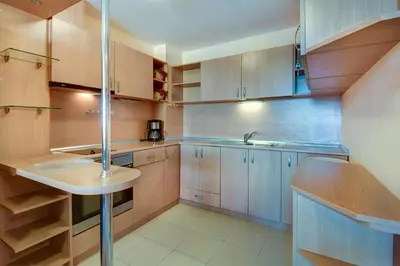 a kitchen with wooden cabinets and a sink at ДриймБг Апартаменти - Панорама Бийч, Несебър in Nesebar