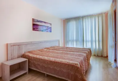 a bedroom with a bed and a large window at ДриймБг Апартаменти - Панорама Бийч, Несебър in Nesebar