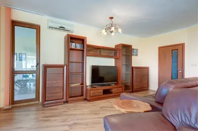 a living room with a couch and a television at ДриймБг Апартаменти - Панорама Бийч, Несебър in Nesebar