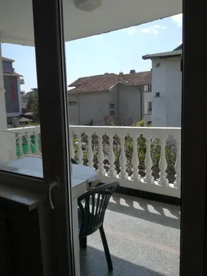 a room with a balcony with a chair and a window at Anele,Kiten in Kiten