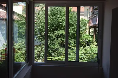 three windows in a room looking out at a tree at Нестандартно Бутиково студио за двама Романтика in Varna City