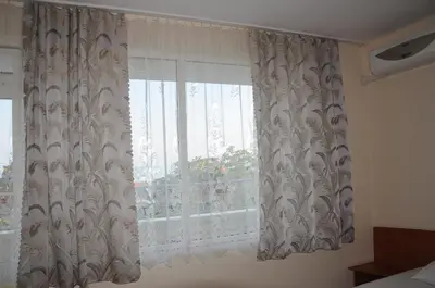 a window with white curtains in a bedroom at Hotel Babeva in Sveti Vlas