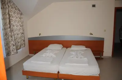 a bedroom with two beds with white sheets at Hotel Babeva in Sveti Vlas