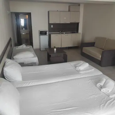 a hotel room with two beds and a couch at Hotel Radis in Kiten