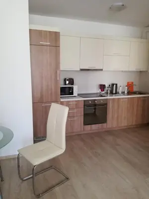 a kitchen with a white chair in a room at Apartament Nora01 in Burgas City