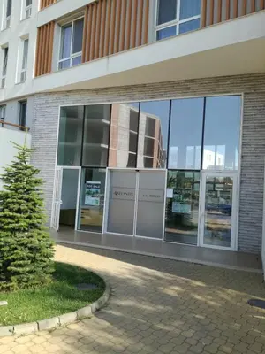 an office building with a tree in front of it at Apartament Nora01 in Burgas City