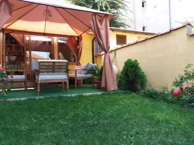 a patio with an umbrella and chairs in a yard at Vila Riviera in Chernomorets