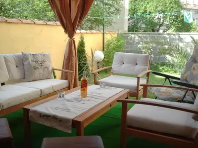 a patio with couches and a table and chairs at Vila Riviera in Chernomorets