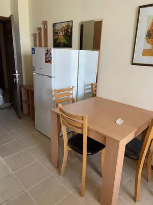 a kitchen with a wooden table and a refrigerator at Julia Vigo Panorama apartments in Nesebar