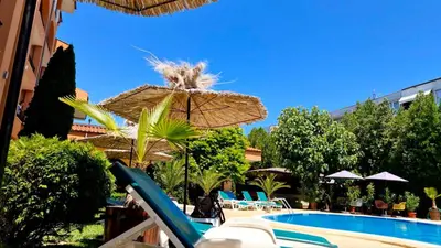 a patio with an umbrella and a swimming pool at Hotel Liani - All Inclusive in Sunny Beach