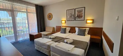a hotel room with two beds and a couch at Hotel Liani - All Inclusive in Sunny Beach