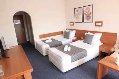 a hotel room with two beds and a tv at Hotel Liani - All Inclusive in Sunny Beach