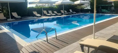 a large swimming pool with chairs and umbrellas at Iva Resort in Byala