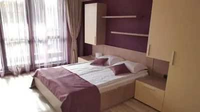 a bedroom with a large bed with purple walls at Iva Resort in Byala