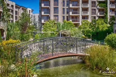 a bridge over a river in a city at Cascadas Family Resort in Sunny Beach