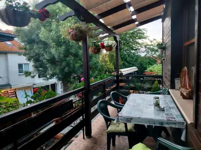 a patio with a table and chairs on a balcony at Guest House Juja in Nesebar