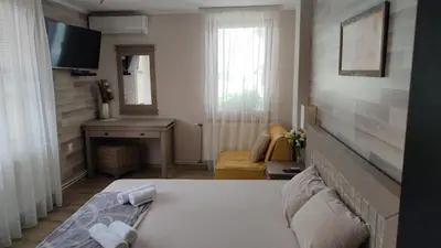 a hotel room with a bed and a television at Guest House Juja in Nesebar