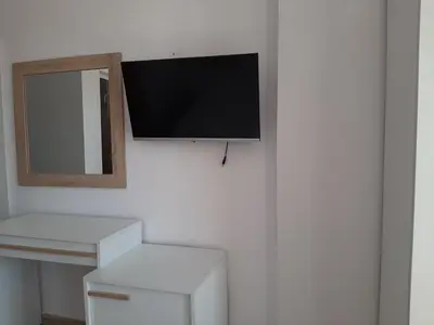 a flat screen tv hanging on a wall at Апартаменти и стаи Мони Холидейс in Tsarevo