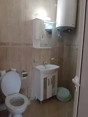 a small bathroom with a toilet and a sink at Апартаменти и стаи Мони Холидейс in Tsarevo