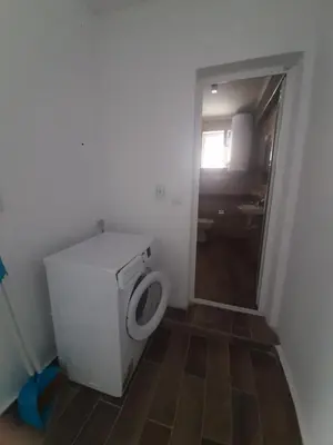 a small bathroom with a toilet and a window at Апартаменти и стаи Мони Холидейс in Tsarevo