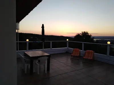 a balcony with a table and chairs and a sunset at Apartament Zaliva in Varna City