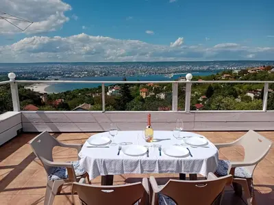 a white table with a bottle of wine on a balcony at Apartament Zaliva in Varna City