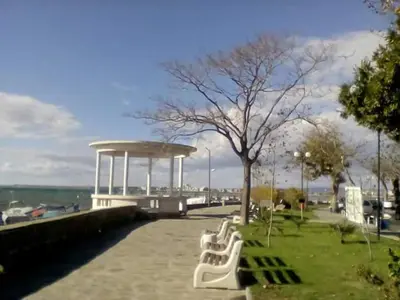 a row of white benches in a park at Hristovi Apartments & Studios in Pomorie