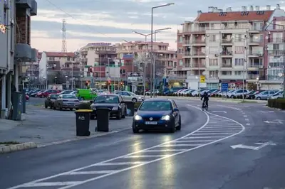 a car driving down a city street with parked cars at Hristovi Apartments & Studios in Pomorie