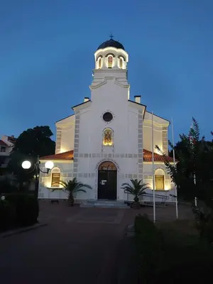 a large white church with a tower at dusk at Hristovi Apartments & Studios in Pomorie