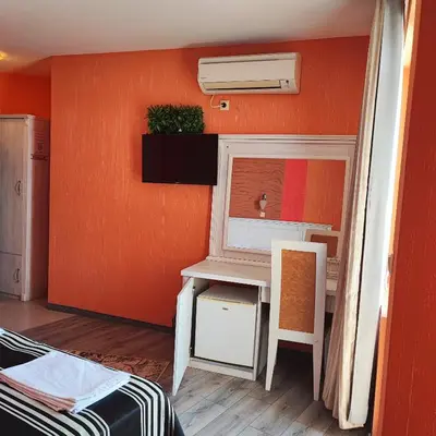 a small room with a desk and a mirror at Family Hotel Paros in Pomorie