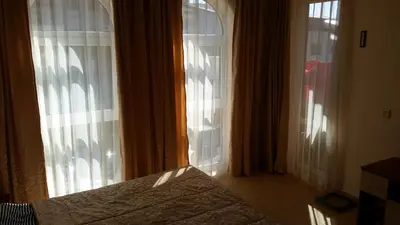 a bedroom with a bed and two large windows at Aqua Dreams - new wifi in Sveti Vlas