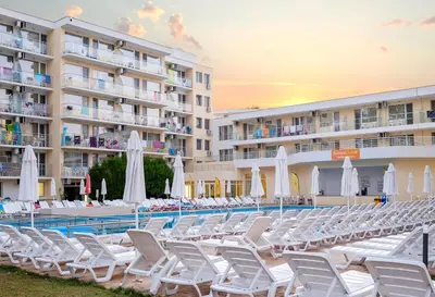 a pool with chairs and umbrellas in front of a hotel at Hotel Garden Nevis - All Inclusive in Sunny Beach