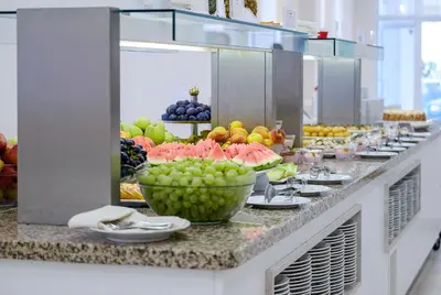a buffet line with bowls of fruit on display at Hotel Garden Nevis - All Inclusive in Sunny Beach