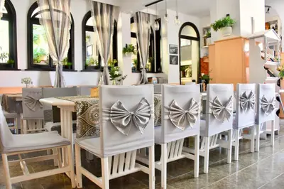 a group of chairs and a table in a restaurant at Family Hotel Apolonia in Sozopol