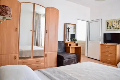 a bedroom with a mirror and a bed and a tv at Family Hotel Apolonia in Sozopol