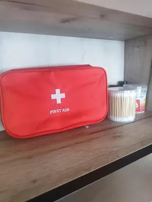a red first aid suitcase sitting on a shelf at Jacky's Apartament - Апартамент в Свети Влас in Sveti Vlas