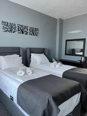 two beds sitting next to each other in a room at Family Hotel Sunrise in Lozenets