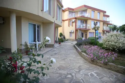 a courtyard of a building with flowers in front of it at Mappy Holidays Aparthotel in Sozopol