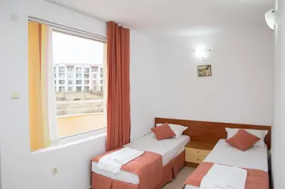 a room with two beds and a window at Mappy Holidays Aparthotel in Sozopol