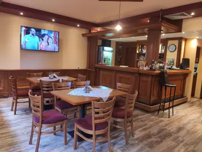 a restaurant with wooden tables and a bar at Family Hotel Denica in Obzor