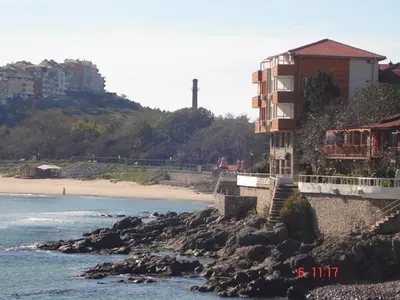a building on a rocky beach next to the ocean at Guest House Rusalka in Sozopol